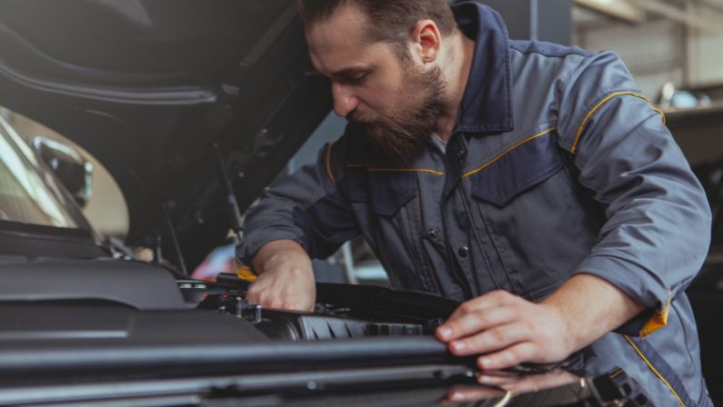 mechanic checking transmission fluid